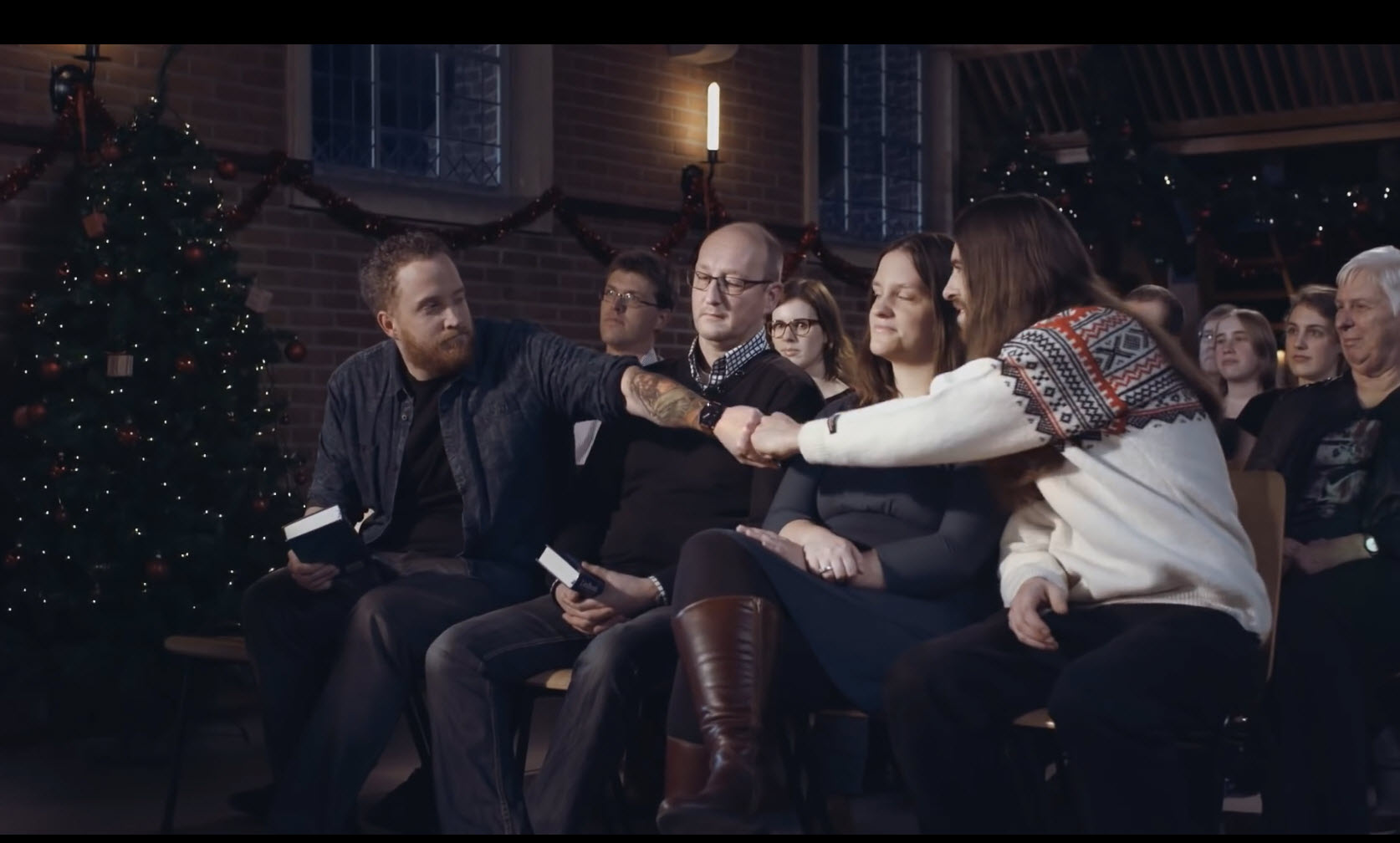 Jezus, in Noorse trui, geeft een boks in de kerk.